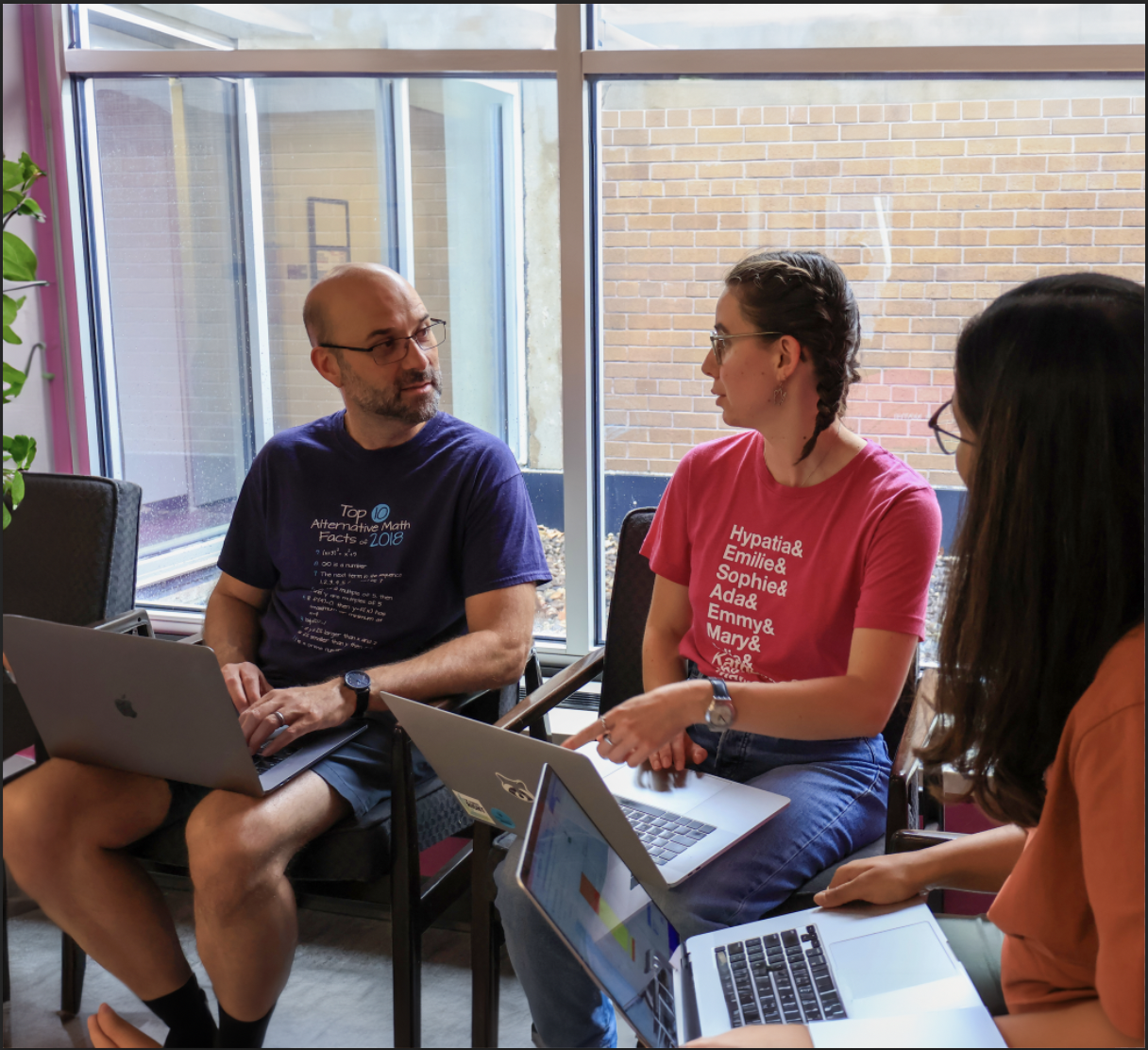 Two adults talking to each other with laptops open