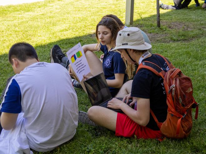 Group of high school students sitting outdoors and problem solving