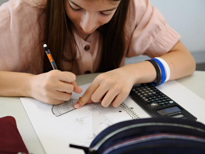 Student problem solving with calculator on the table
